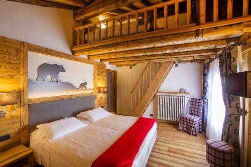 una camera con letto in una stanza con soffitti in legno di Hotel Pilier D'Angle & Wellness a Courmayeur