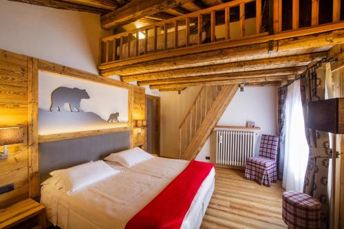 - une chambre avec un lit dans une pièce dotée de plafonds en bois dans l'établissement Hotel Pilier D'Angle & Wellness, à Courmayeur