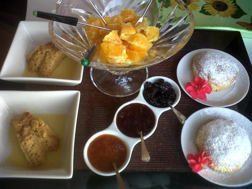 a table with plates of desserts and a bowl of fruit at Residence Sa Pintadera in Càbras