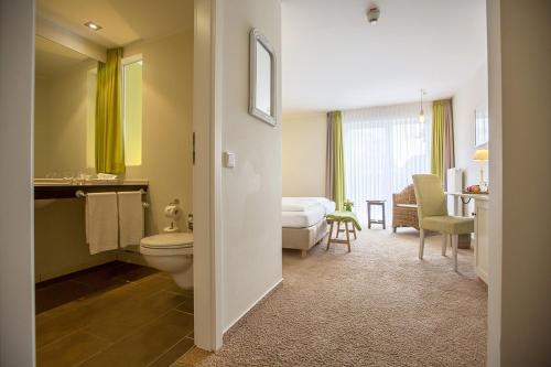 łazienka z toaletą i łóżko w pokoju w obiekcie Paulsen's Landhotel und Restaurant w mieście Bohmstedt
