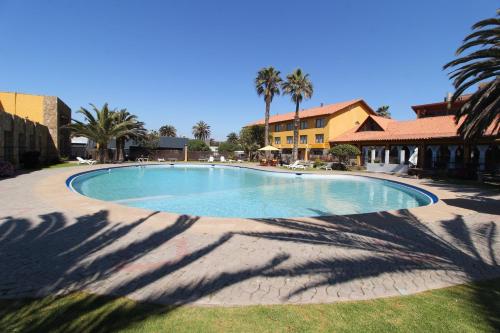 a large swimming pool in a resort with palm trees at Hotel La Serena Plaza in La Serena