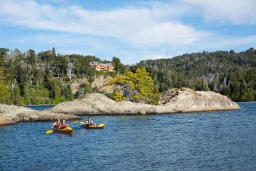 a group of people in kayaks on a lake at Hostería Isla Victoria Lodge in Isla Victoria