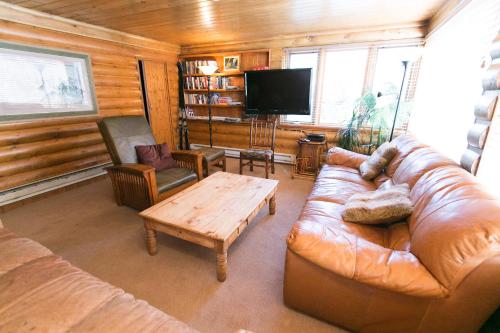 a living room with a leather couch and a coffee table at Silver Fork Lodge & Restaurant in Brighton