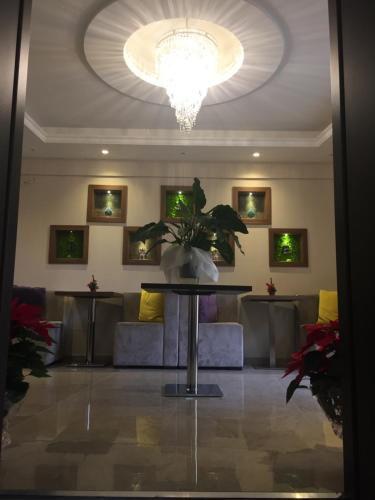 a room with a table and a couch and a chandelier at Beatus Suites And Rooms B&B in Canicattì