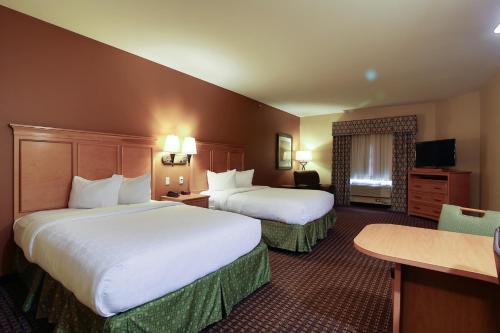 a hotel room with two beds and a television at TownePlace Suites by Marriott Minot in Minot