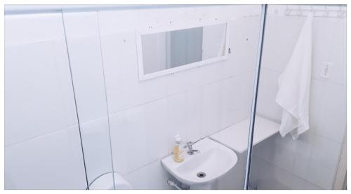 uma casa de banho branca com um lavatório e um espelho em Hostel Santana - Metrô Santana em São Paulo