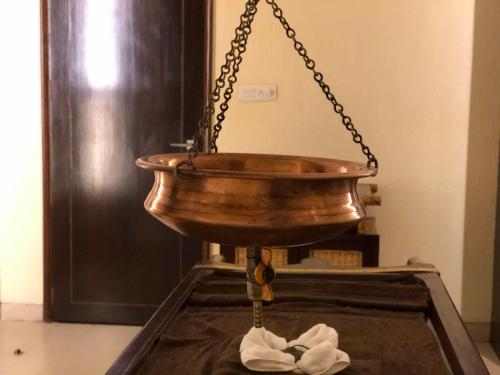 a copper bowl hanging from a chain at Evershine Resort & Spa in Mahabaleshwar