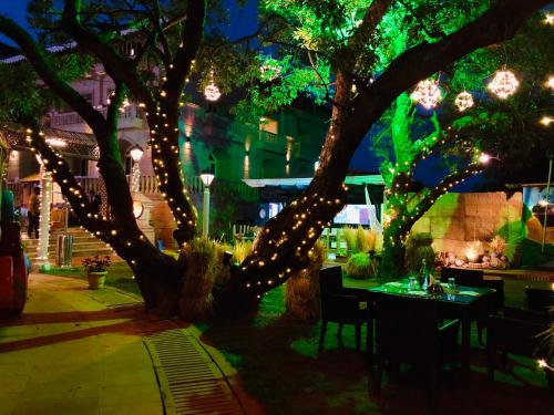 a tree with lights on it next to a restaurant at Evershine Resort & Spa in Mahabaleshwar