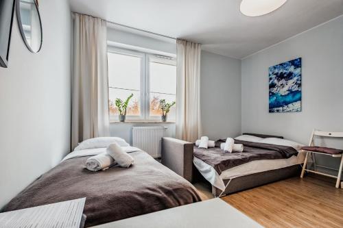 a bedroom with two beds and a window at Apartamenty Novomiejska 17 in Lublin