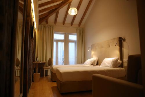 a bedroom with a large bed and a window at Muralha Charm House in Lamego