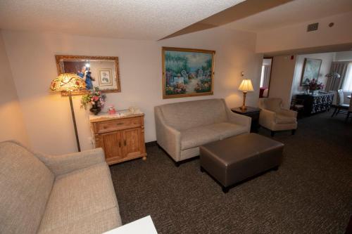 a living room with a couch and a chair at Hotel Grand Victorian in Branson