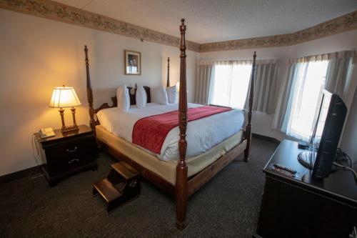 a hotel room with a bed and a television at Hotel Grand Victorian in Branson