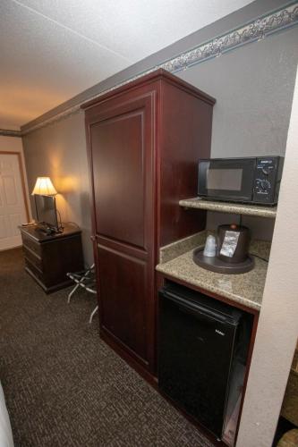 a hotel room with a microwave and a refrigerator at Hotel Grand Victorian in Branson