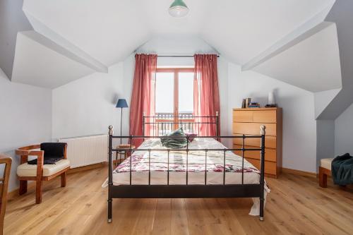 a bedroom with a bed and a chair and a window at Dom w Grodzisku in Skała