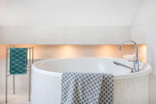 a bath tub in a bathroom with a sink at Dom w Grodzisku in Skała