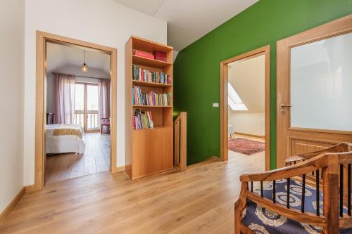 a room with a green wall with a book shelf at Dom w Grodzisku in Skała