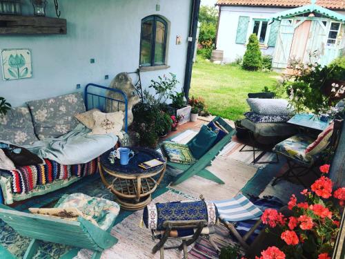a patio with chairs and a couch and a table at Pod tulipanem nad jeziorem in Zawady Oleckie