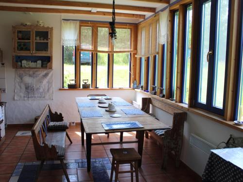 a dining room with a table and some windows at Pod tulipanem nad jeziorem in Zawady Oleckie