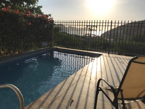 a swimming pool with a chair next to a fence at Casa Mirador del Cielo in Taganga