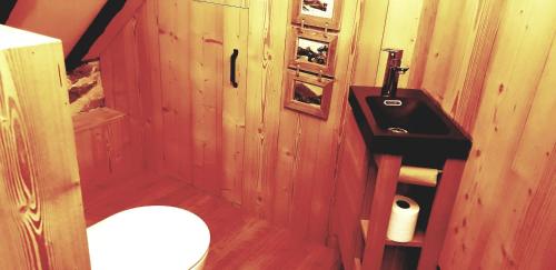 a wooden bathroom with a sink and a toilet at La Bergerie de Louvie in Louvie-Soubiron