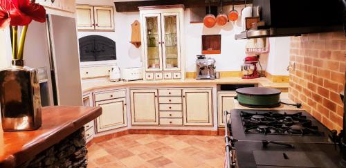a kitchen with white cabinets and a stove top oven at La Bergerie de Louvie in Louvie-Soubiron
