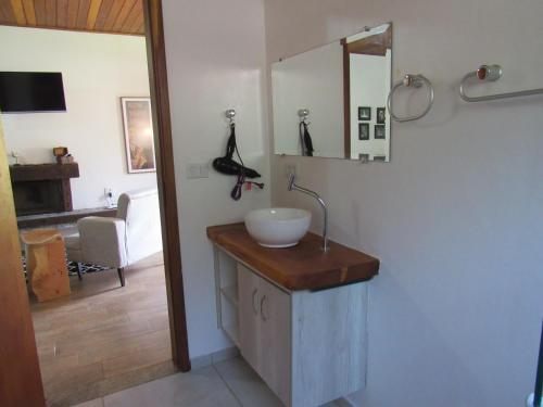 a bathroom with a sink and a mirror at Chalés Luar da Serra in Santo Antônio do Pinhal
