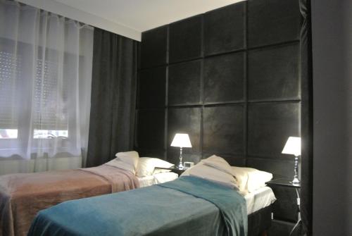 ジェロナ・グラにあるTwo-bedroom Apartmentのベッドルーム1室(ベッド2台、黒いヘッドボード付)