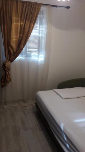 a bedroom with a bed and a window with a curtain at Studio Jeff 1 in Kotor
