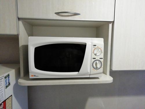 a microwave sitting on a shelf in a kitchen at Depto 2 amb Cochera zona Bristol Casino 1 cuadra del mar Solo familias in Mar del Plata