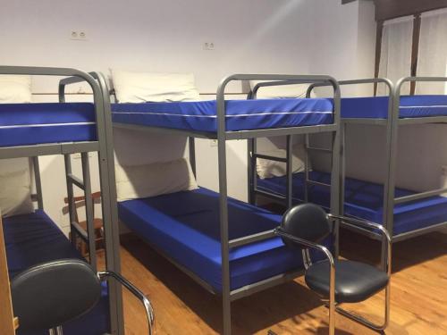 two bunk beds in a room with blue beds at El Pajar de Oncina Albergue Peregrinos in Oncina de la Valdoncina