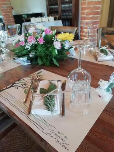 a table with a table set with flowers and glasses at Agriturismo La Rinaldina in Faenza