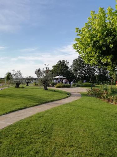 a path through a park with green grass and trees at Agriturismo La Rinaldina in Faenza