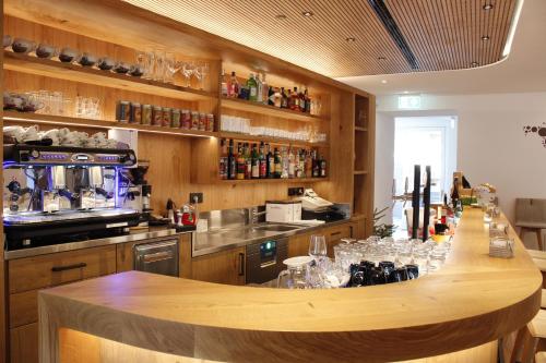 a kitchen with a bar with wine glasses at Gasthof Zum Hirschen Margreid in Magrè allʼ Adige