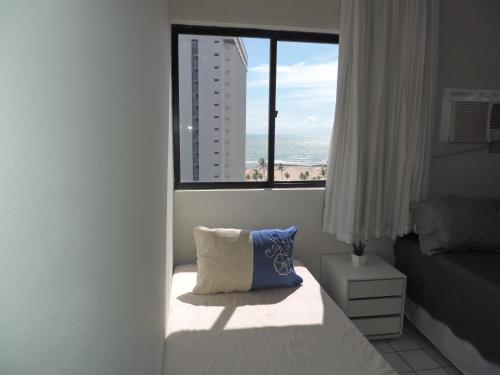 um quarto com uma cama e uma janela com vista para o oceano em Flat Pina/Boa Viagem em Recife