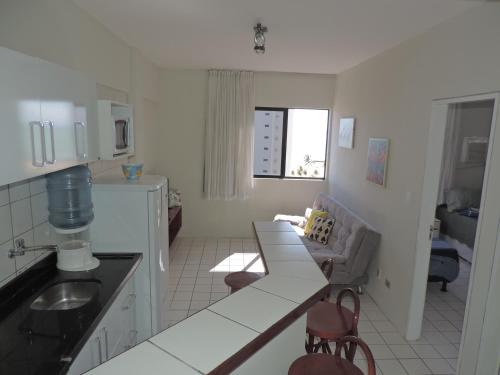 uma cozinha com uma mesa e um sofá em Flat Pina/Boa Viagem em Recife