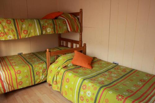 dos camas sentadas una al lado de la otra en una habitación en Cabañas Don Gaspar, en Valdivia