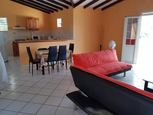 a living room with a red couch and a table at chez jojo in Baie-Mahault