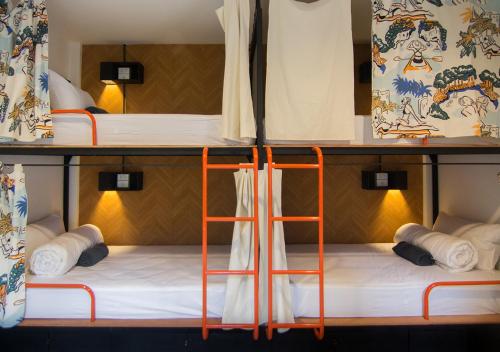 two bunk beds with orangeadders in a room at TAN Hostel x Cafe , Aonang Beach in Ao Nang Beach