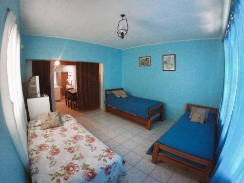1 dormitorio con paredes azules, 1 cama y 1 mesa en Cabaña Pichidangui, en Pichidangui
