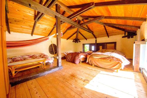 1 Schlafzimmer mit 2 Betten in einem Zimmer mit Holzböden in der Unterkunft Muumin Farm in Nakijin