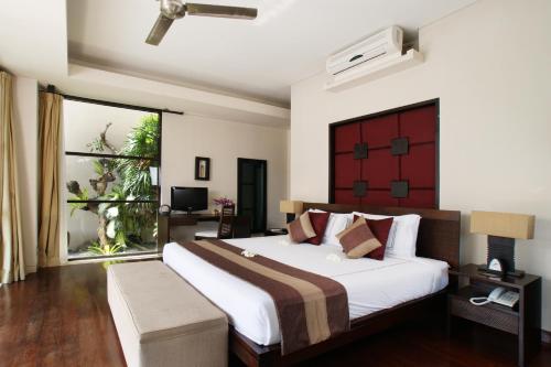 a bedroom with a large bed and a large window at Temple Hill Residence Villa in Jimbaran