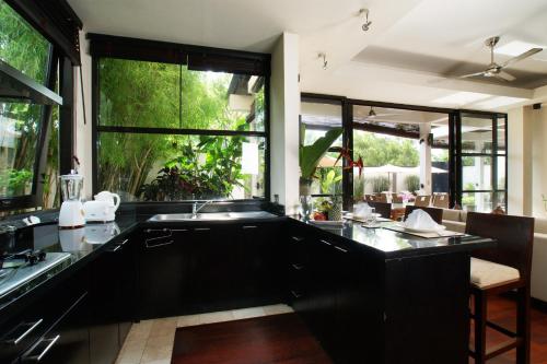 a kitchen with a sink and a large window at Temple Hill Residence Villa in Jimbaran