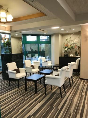 a waiting room with white chairs and tables in a salon at Hotel Musashino no Mori in Fuchu