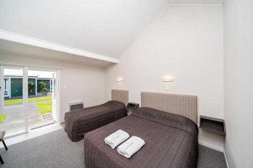 a bedroom with two beds and a window at The Furlong in Hawera