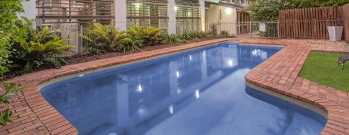 a swimming pool with a cat sitting on top of it at Airport International Hotel Brisbane in Brisbane