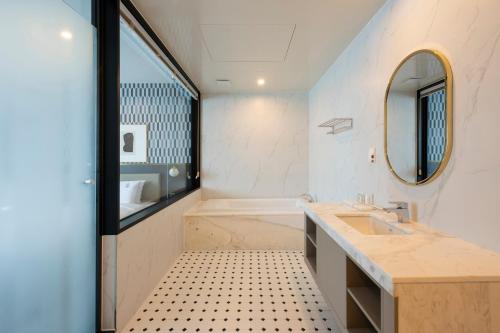 a bathroom with a tub and a sink and a mirror at Browndot Business Seomyeon in Busan