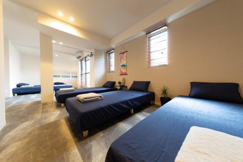 a bedroom with two beds and a couch at Guest House MEGU-chan in Osaka