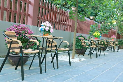 a row of tables and chairs with flowers on them at Tam Coc Legend Hotel in Ninh Binh