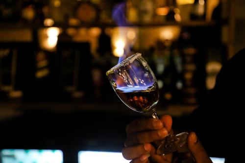 a person is holding a glass of wine at Calux Grand Baga - Formerly Amara Grand in Baga