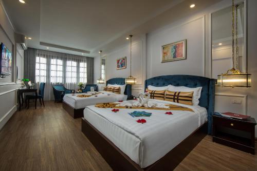 um quarto de hotel com duas camas e uma área de jantar em S Central Hotel and Spa em Hanói